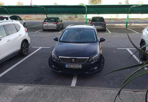 Um carro estacionado entre dois lugares de estacionamento.