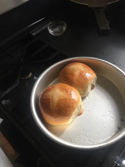 Perfectly baked and browned traditional hot cross buns in a pan. sunny morning light.