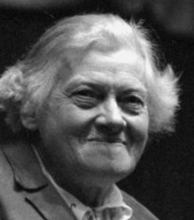 Lois Blake as an older woman; a white woman with white hair, smiling
