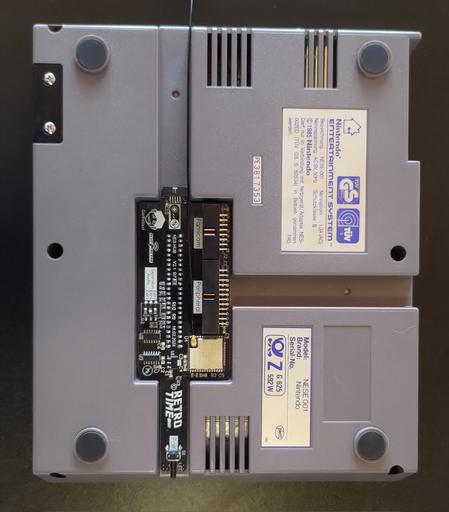 The underside of the NES, with the NES hub inserted.  It fits perfectly and even exposes the pairing button to the side of the console.