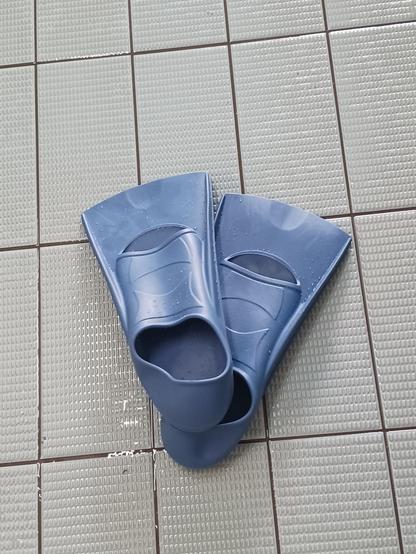 Paire de palmes de natation sur le sol carrelé de la piscine