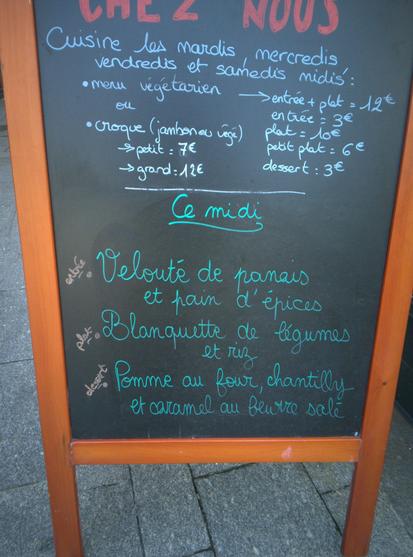 Photo du chevalet du café Chez Nous affichant le menu du 19 Mars 2024 :
- entrée : velouté de panais et pain d'épices
- plat : blanquette de légumes et riz
- dessert : pomme au four, chantilly et caramel au beurre salé