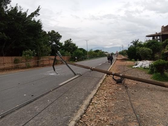 Un poteau électrique en bois couché sur la route. Les fils sont à même le sol...