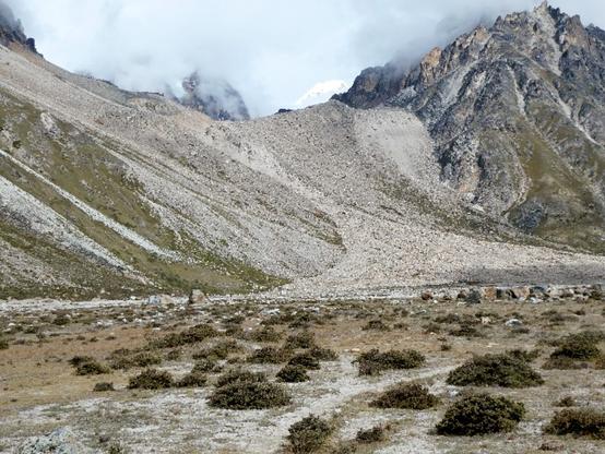 A steep glacier moraine in the Lhonak valley of Nepal has an incised channel that feeds an alluvial fan of boulders.  This fan is the probable path of glacial lake outburst flood.