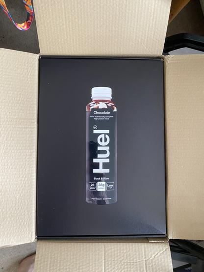 Black cardboard box with picture of a Huel black bottle on it