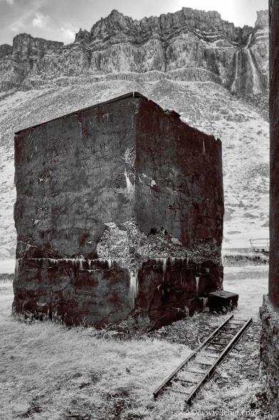 A large concrete cube with a ladder on the ground in iceland