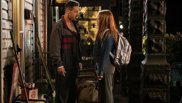 Theo Rossi and Sadie Sink as father and daughter stand on a cluttered front porch on a dark night.