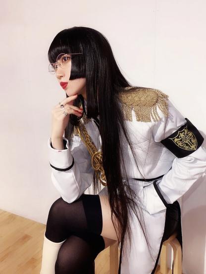 Himari dressed as Persephone sits in the thinker position.