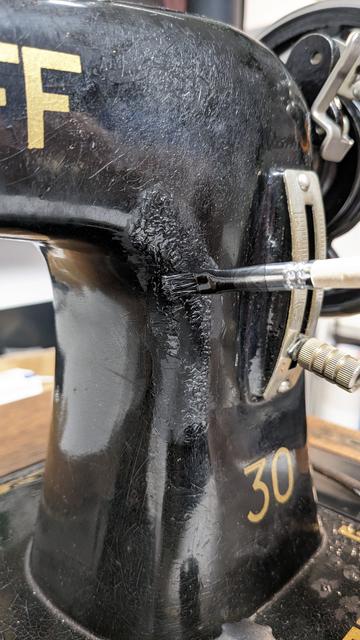 the same area being fixed up with a small paint brush and black shellac