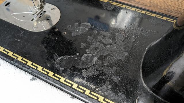 large areas of lacquer are missing on the bed of the machine; they've been generously filled with one layer of black shellac already. Luckily the golden ornamental banding around it is still almost completely intact.