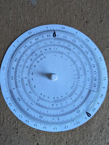 Paper circular slide rule showing the answer 42.
