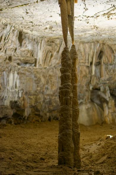 Two close by stalactites just touching two close by stalcamites.