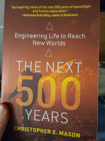 Cover of The next 500 years with a Martian orange hue and an astronaut behind the title
Subtitle is engineering life to reach new worlds