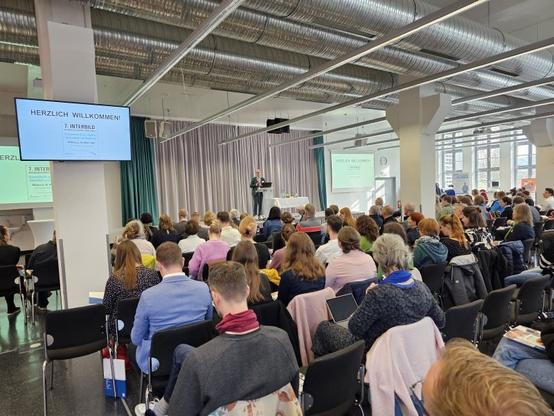 Prof. Dr. Stephan Degle begrüßt die rund 200 Gäste des 7. INTERBILD Symposiums; Foto: Christina Nolte