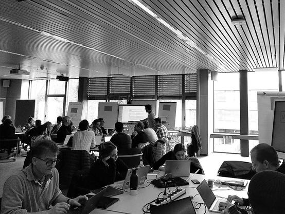 People in a conference room working in teams at a hackathon