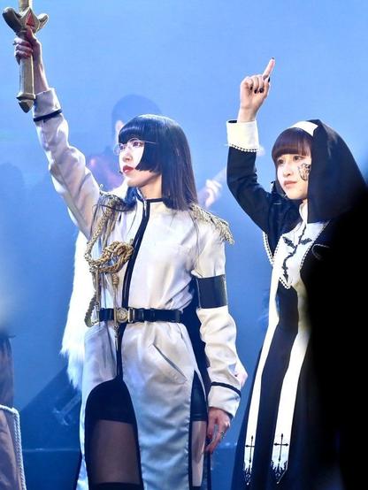 Perephone and her sister the nun hold up a hand in salute