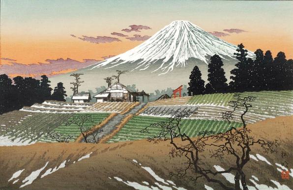 A view looking out over tidy farmlands toward Mt Fuji on a spring day. In the foreground, a few wiry leafless trees stand on a hill; just below, rolling fields are carfeully divided into rectangular sections filled with rows of sprouting plants. Snow still clings to some of the spaces between the rows, and in the hollows of the hilltop. Beyond the fields, a house stands on a rise, commanding a good view of the farm; tall dark trees surround it on either side. A torii gate and the tops of other houses can be seen just beyond. Further on, the unmistakable sight of Mt Fuji dominates the horizon, the snowy flanks of the mountain contrasting against a sky tinted with warm orange and dusty rose-coloured clouds.