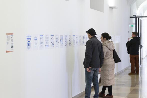 The same wall as in the first picture, now zoomed back a bit to show visitors of the exhibition reading the comic.