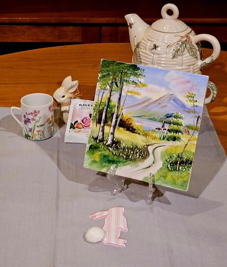A tea tableau of a bunny about to follow a trail to find tea, which is a rose & mint herbal.