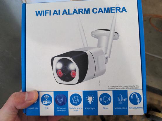 A securiry camera box in white and blue, with a picture of the camera on the front. The box reads "WIFI AI ALARM CAMERA".