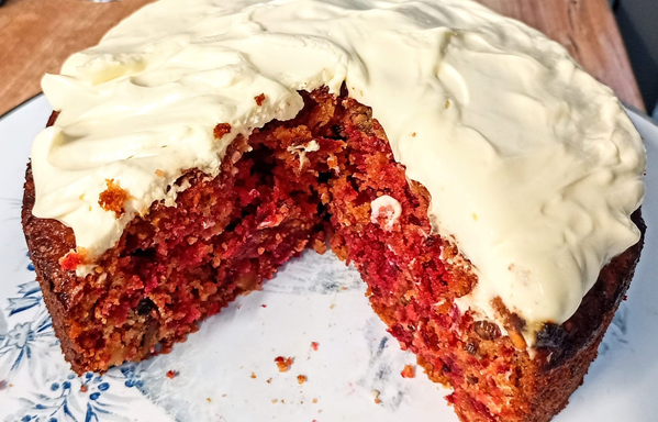 Der fertige Kuchen ist angeschnitten, er ist innen leuchtend rot. Oben drauf ist die Mascarpone-Schicht