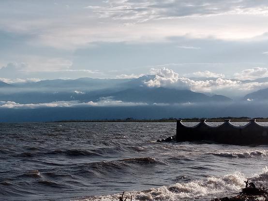 Sunsubiro super la Tanganjika lago - la ĉielo estas minacanta. Oni vidas ankaŭ ke la akvo inundas la strandon