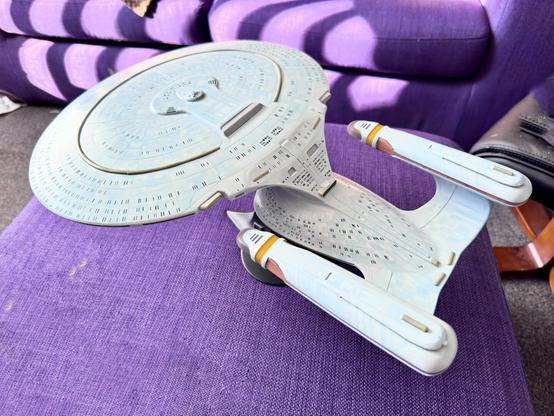 Galaxy class model sitting on a purple footstool