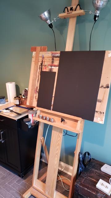 Blank black gesso canvas boards on an easel