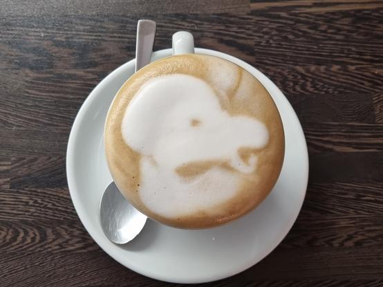 Ein Gesicht das grantig im Schaum eines Cappuccino zu erkennen ist.