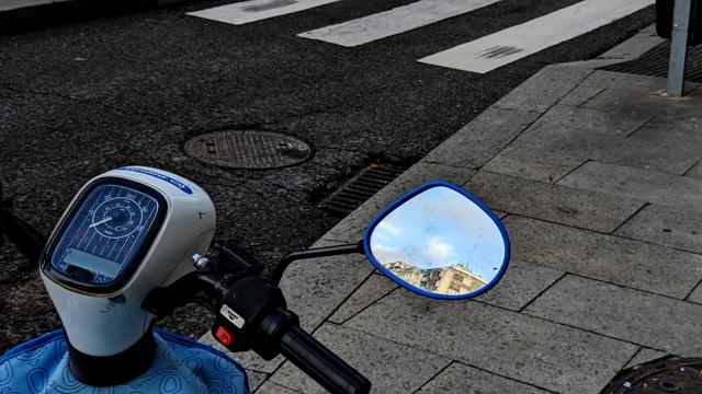cielo de Madrid reflejado en espejo de moto azulada. el espejo tiene un borde azul