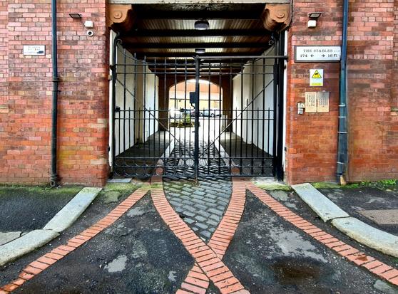 Lines of bricks forming tranways at the entrance to a late Victorian stables.