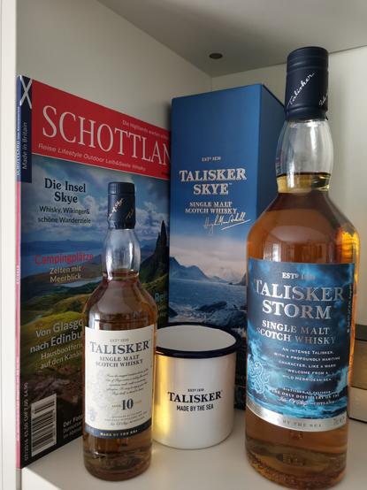 Arrangement von Whiskyflaschen und Becher der Marke Talisker