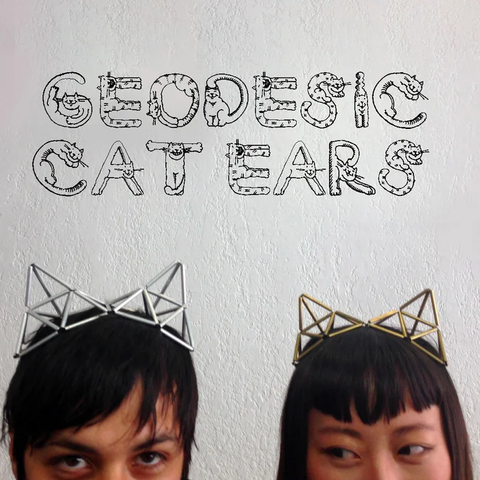 Photo from the geodesic cat ears Instructable. It shows two people wearing geodesic cat ears. There are no LEDs, yet.