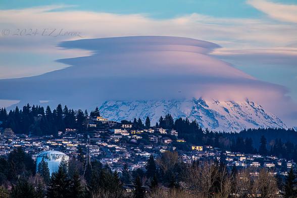 Closeup image of Tahoma with lenticular clouds towering above a residential, hilly neighborhood late afternoon.