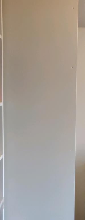 Une vue du côté gauche de l'armoire. On distingue quelques trous près du bord droit (à l'avant de l'armoire)