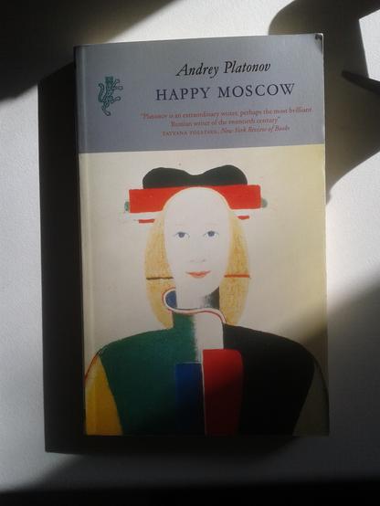 Cover of Andrey Platonov, Happy Moscow, schematic painting of a smiling woman  'Girl with the hat' by Malevich