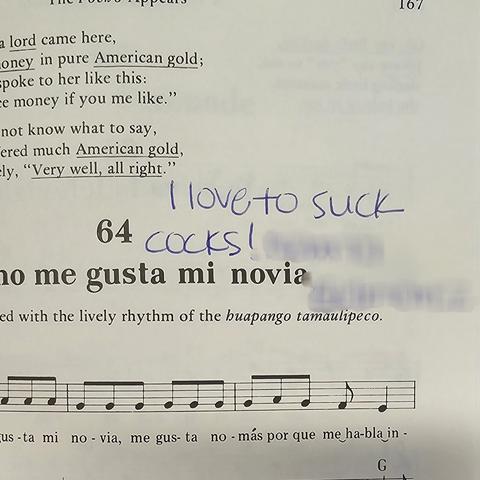 Photo of the defaced page in question, focused entirely on the note written. Note is in blue ink and it reads: I love to suck cocks" with the (alleged) inscriber's name blurred out (my edit).

What humors me is that just below this is a song title. I did not get the entire title but just the last words, '...no me gusta mi novia" which translates to: I don't like my girlfriend/fiancée/bride (though it's mostly used for the first two).