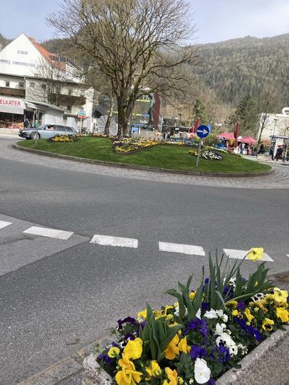 Panoramabild von einem Platz in Kufstein, mit spriessenden Blumen im Trog.