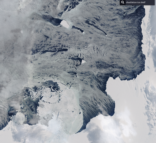 satellite image showing white blocks of ice and swirls of drifting snow, clouds and out in the blue ocean sea ice