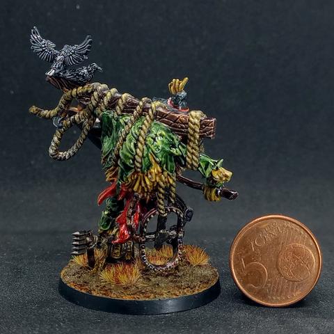 Back of the same figure. There's a bear trap hanging from some rope on its back.