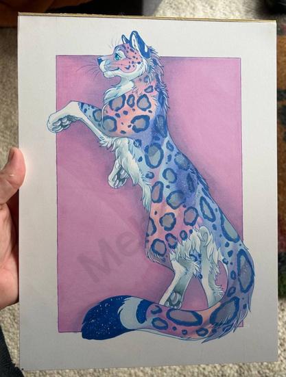 Illustration of a snow leopard with pink, blue and purple hues, standing upright against a pink background, held by a hand.