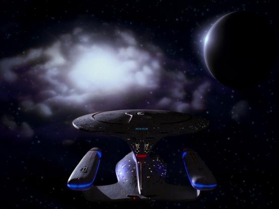 Enterprise D flying towards a strange cloud and planet.