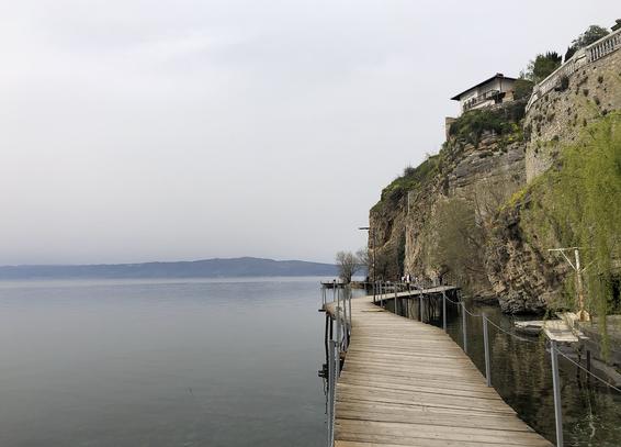 Ohrid landscape: a lingering slate pier alongside a high cliff, with buildings on top of it. It was a tad scary to walk in the darkness, but hey, living on the edge!