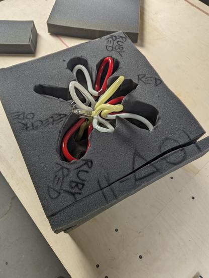 A cavity pack of this Ruby Candlelight Fleshtone Burst. I miscut the foam, but now it has an easy removal key (cardboard tightly wraps around its sides) More foam layers get cut to wrap the shape in grey urethane foam.