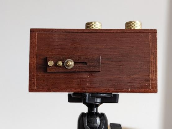 photo of wood pinhole camera made by Zero Image. Model is 135 dual format: traditional and panoramic 135 film.