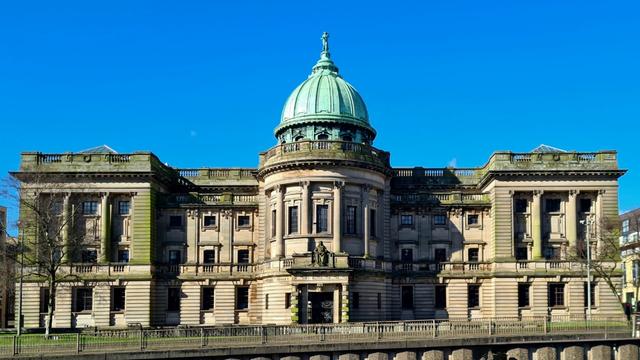 An Edwardian baroque sandstone building topped by a verdigris-covered dome.