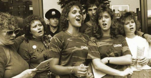 Women strike supporters, singing, wearing camouflage t-shirts.