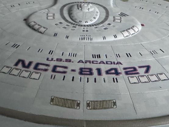 Closeup of the top of the Arcadia’s saucer section showing its name and registry