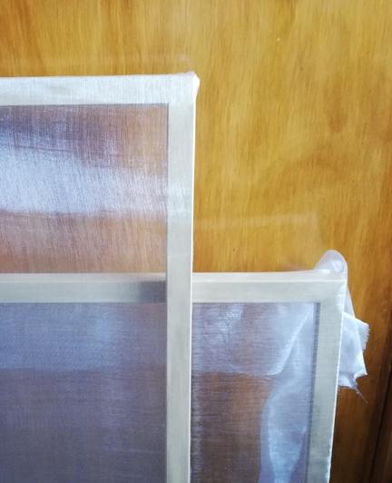 Two frames with gauze stretched over them, one taut, finished and trimmed, the other very much not!
