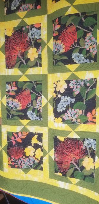Hawaiian quilt with many flowers and colors.